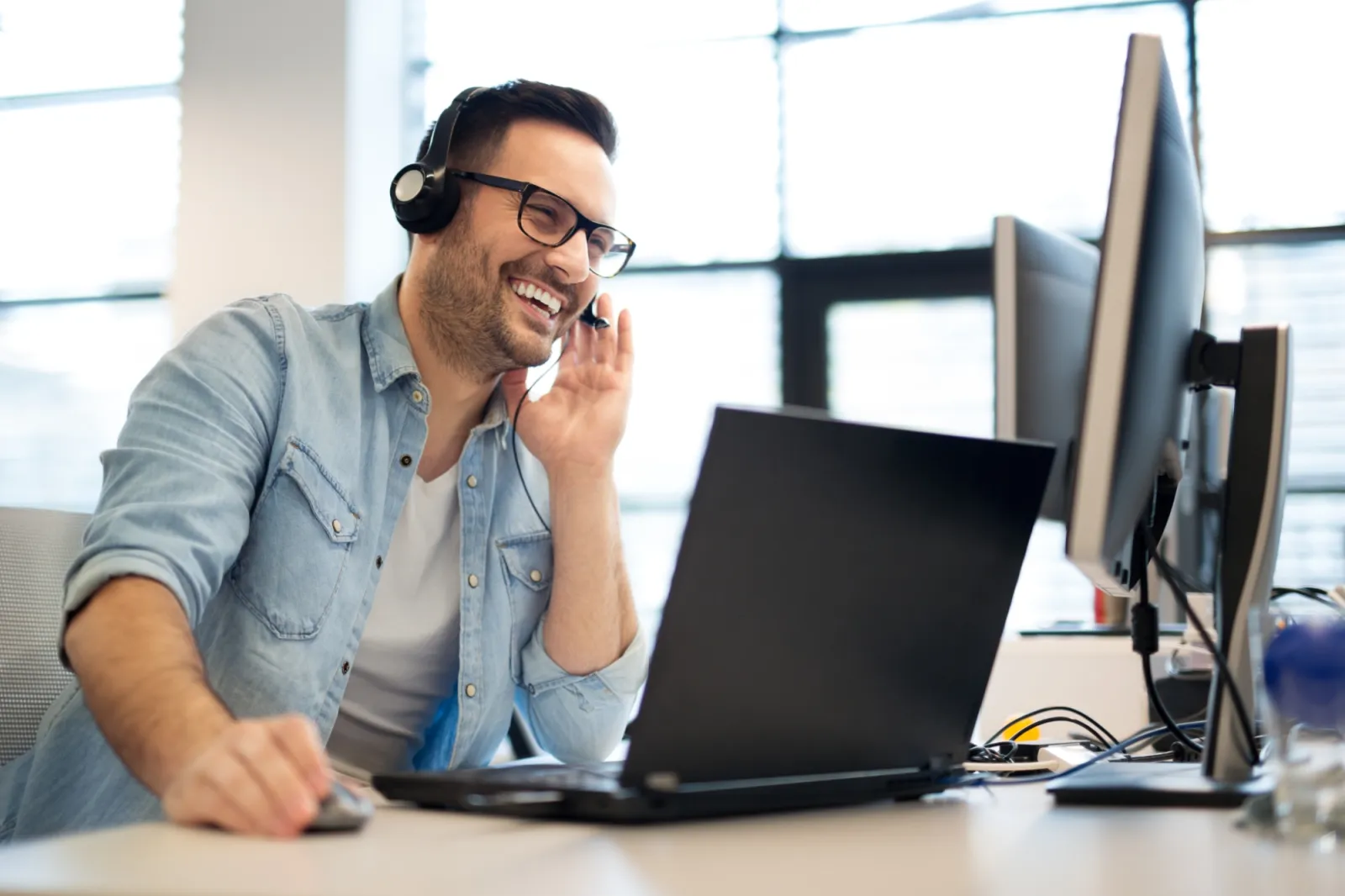 Support representative working at a computer with a headset