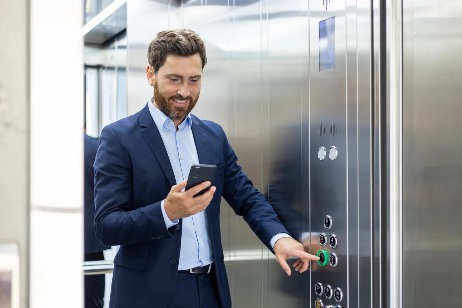 Hotel professional using a smartphone in an elevator