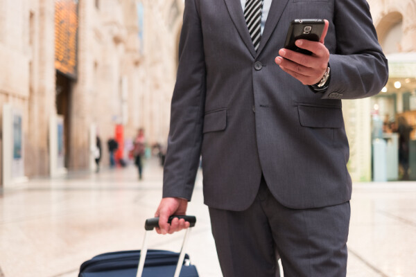 A business guest refers to the hotel's check-in email on his mobile as he makes his way to the hotel.