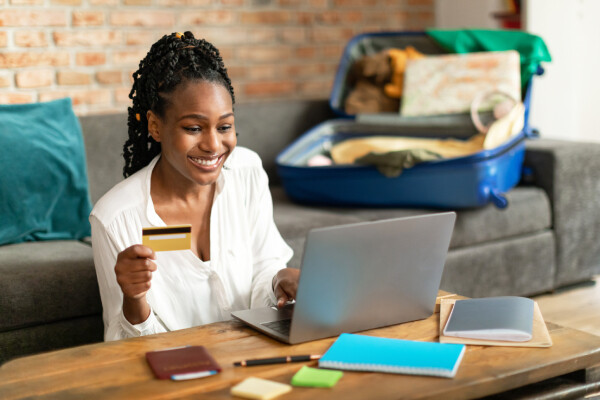 A smiling traveler receives immediate confirmation after booking a hotel stay online.