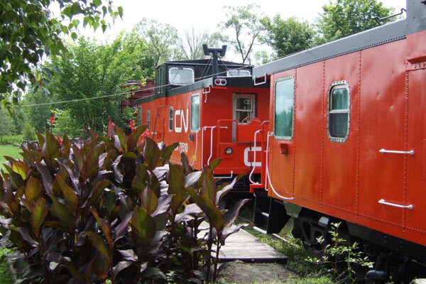 Red train cars await overnight guests at Train Station Inn