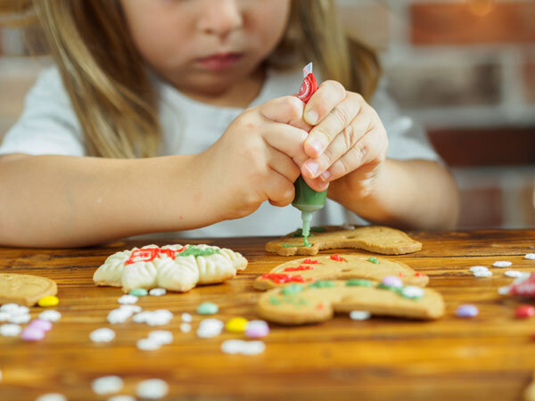 A young child decorates Christmas cookies with full concentration!