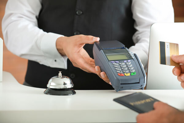 A guest makes a chip and PIN credit card payment at the hotel front desk