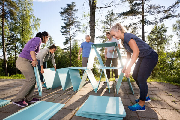 A group of coworkers stacks giant cards as part of a fun team-building activity