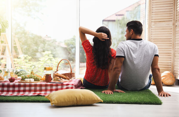 A couple enjoy an in-room picnic