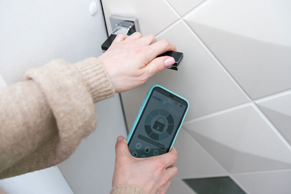 A guest unlocks their hotel room with their mobile phone using a mobile key app.