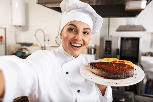 A hotel chef takes a selfie with a dish she just made