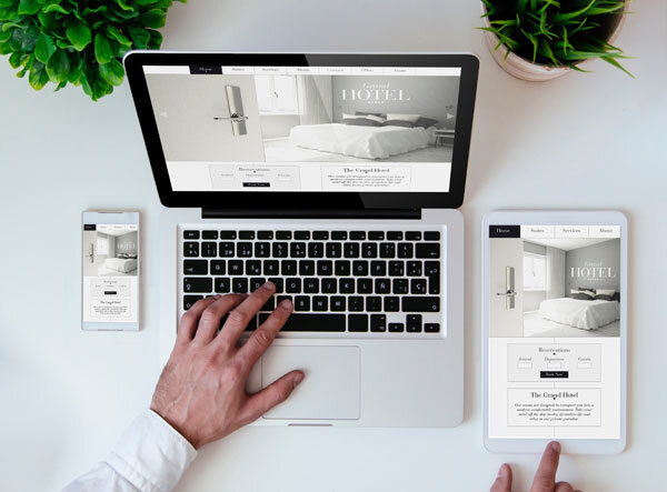 A person enjoys a seamless user experience of a hotel website across a laptop and mobile devices.