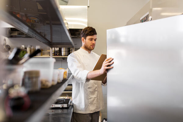 A chef checks his food supplies against his list.