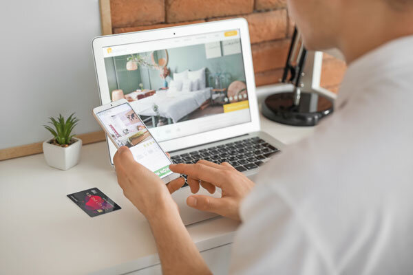 A person books a hotel online using their mobile device