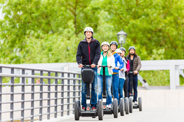 A group of smiling guests explore the city on a guided Segway tour!