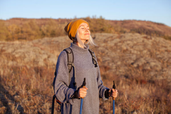A woman soaks in the views and fresh air while hiking in the hills.