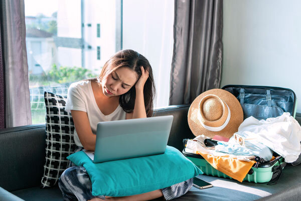 A would-be traveler sadly cancels her booking online.