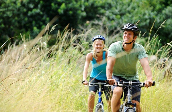 A couple enjoys a bike ride in the sunshine.