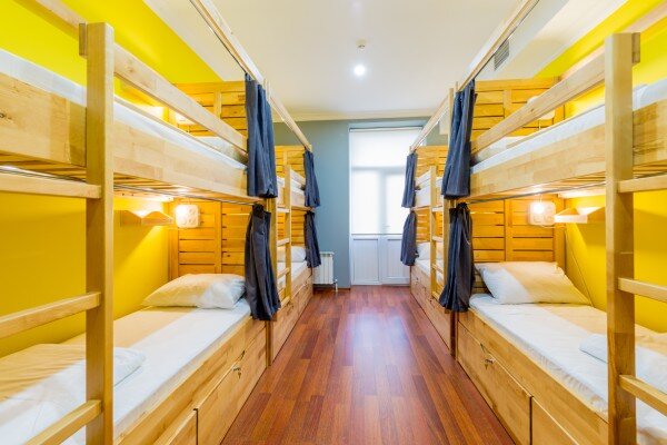 A clean, well-equipped, and nicely decorated hostel dorm ready for guests.