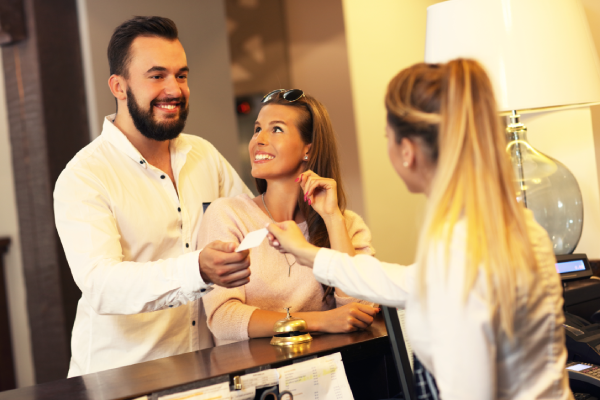 A happy couple receive a free room upgrade at the front desk.